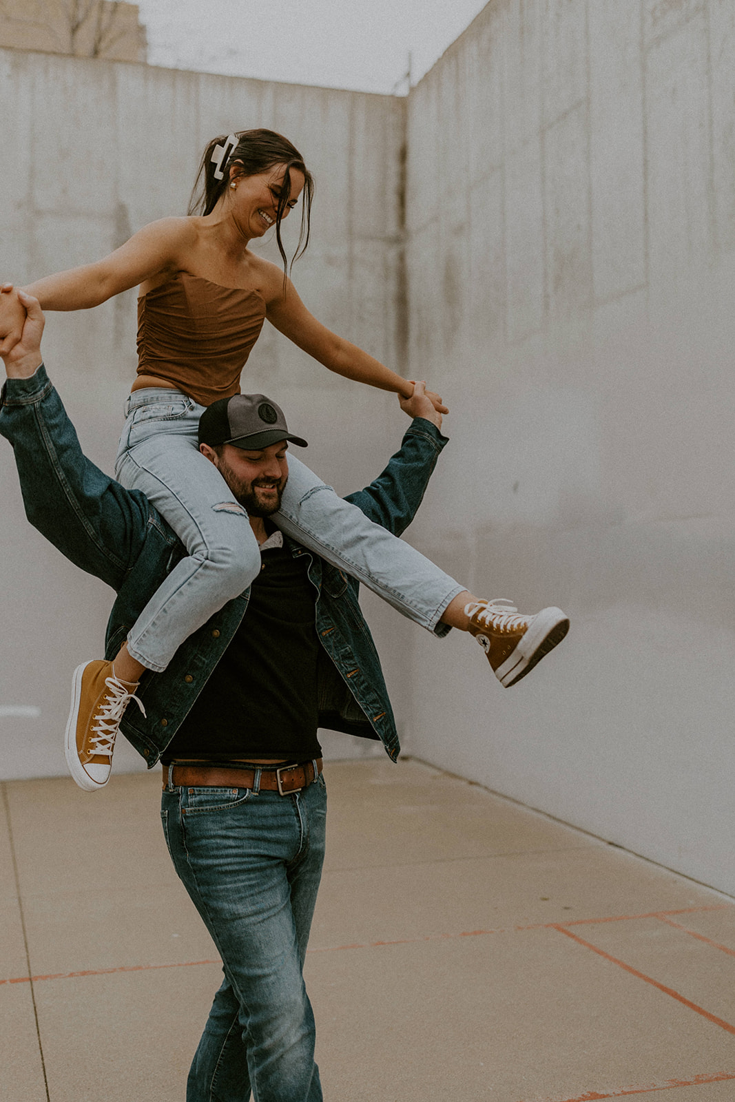 Guy carries his fiance on his shoulders during their engagement session with McKenna Christine Photography