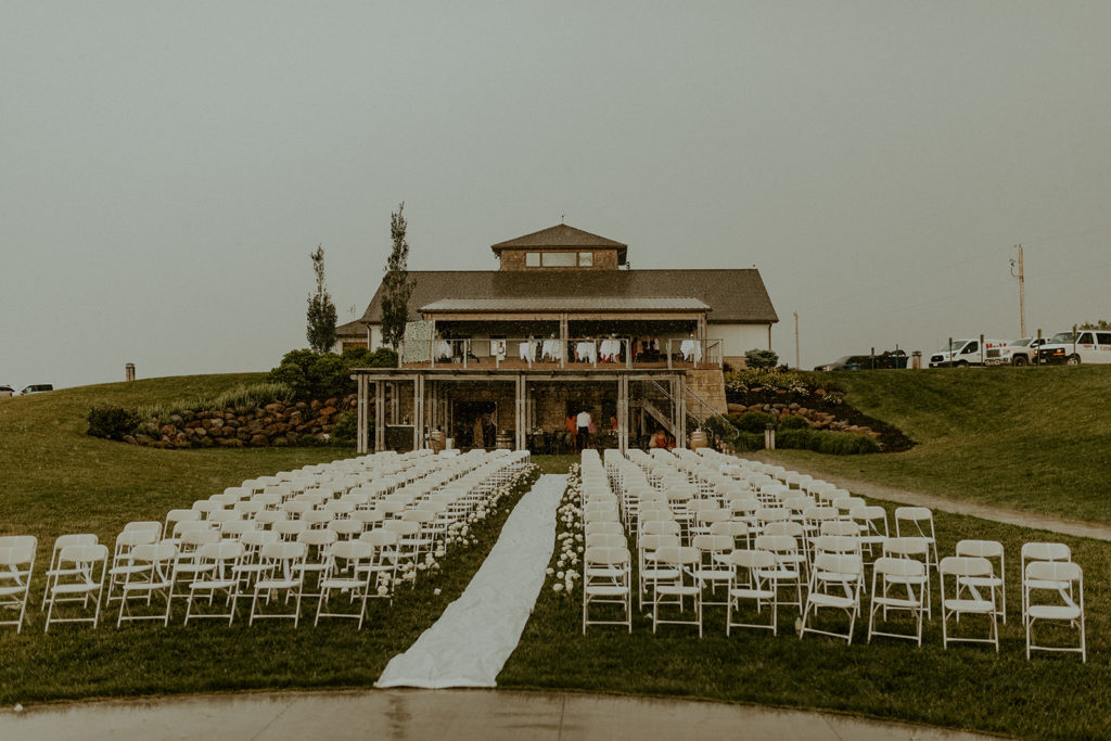 View of Glacial Till Vineyard with white chairs and an aisle lined with flowers