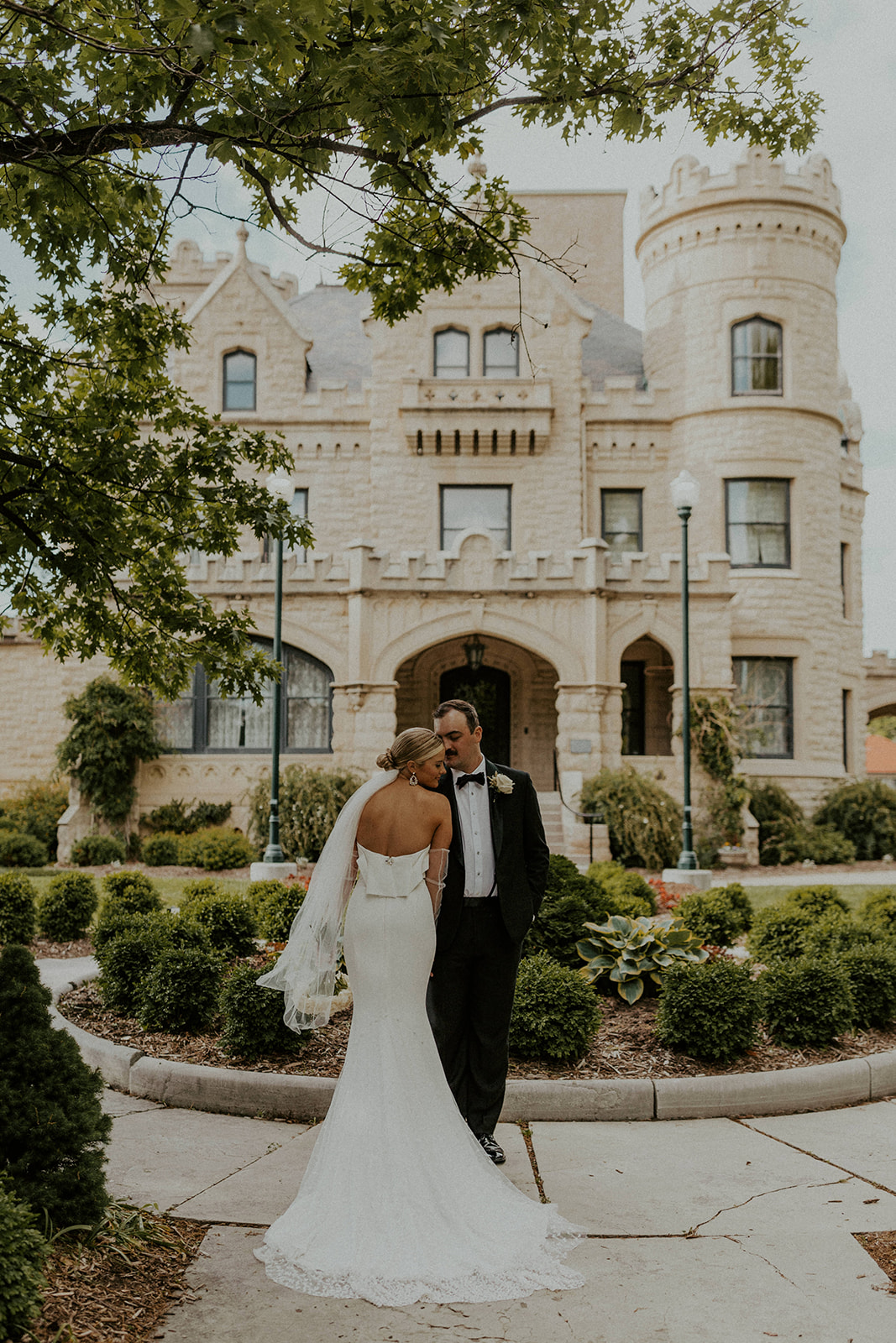 Couple posing with each other in front of picturesque venue, captured by McKenna Christine Photography