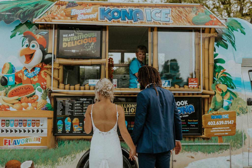 Bride and groom holding hands and standing in front of a food truck they hired for their wedding, taken by McKenna Christine Photography