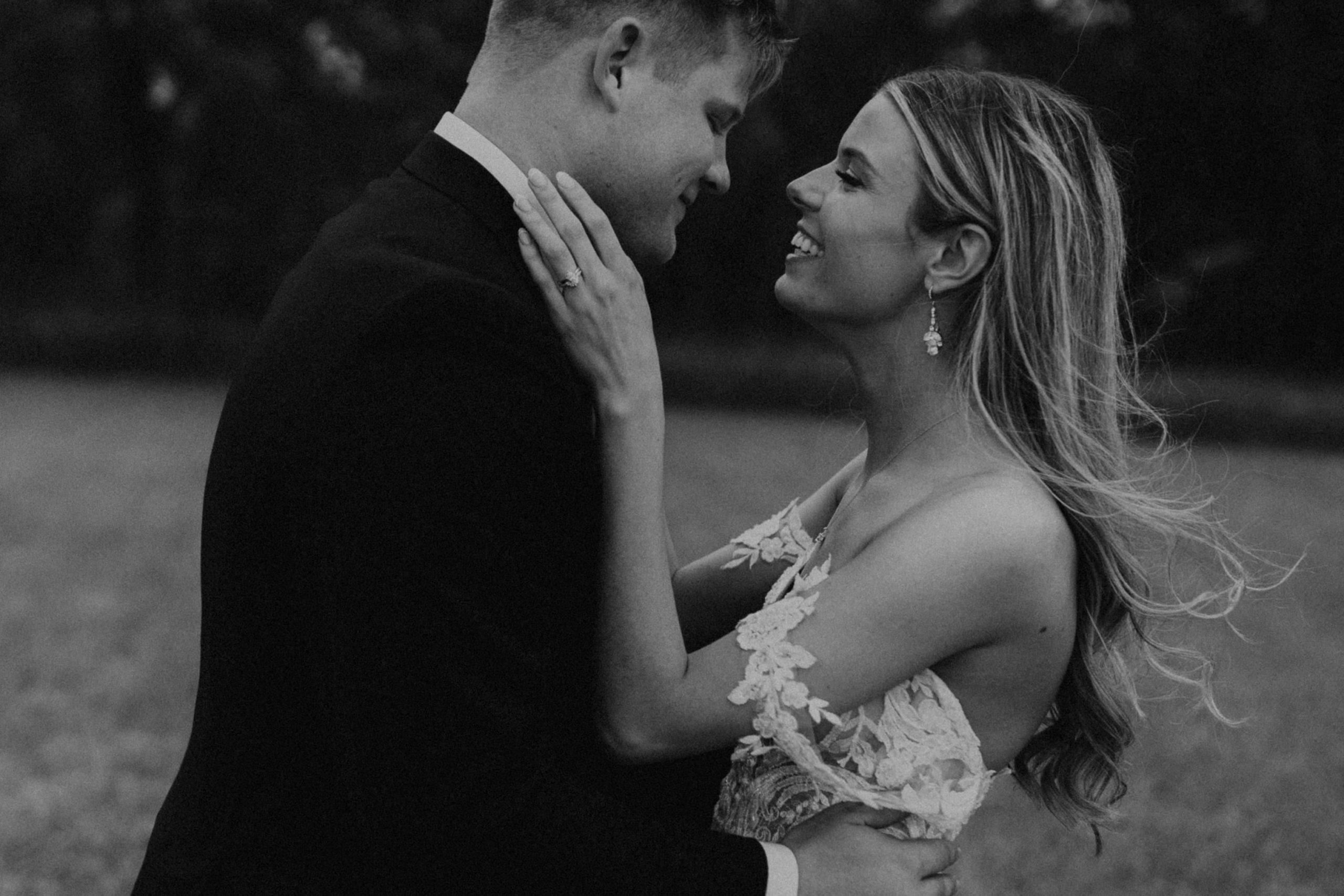 Black and white photo of bride and groom smiling at each other during their Roca Berry Farm wedding shoot with McKenna Christine