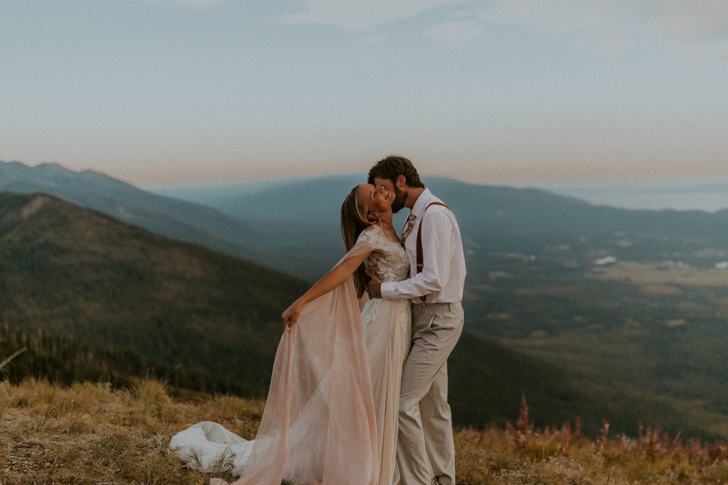 Couple sharing an embrace with breathtaking mountain view behind them at Mount Vernon Canyon Club, one of the best wedding venues in Northern Colorado