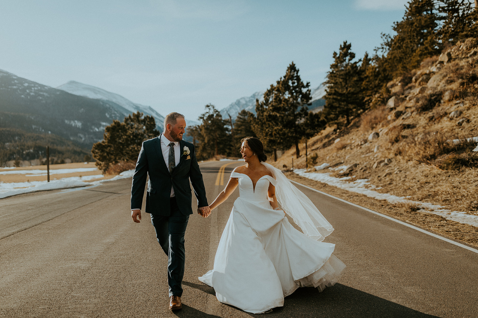 Couple running on the road during their Northern Colorado wedding shoot with McKenna Christine Photography