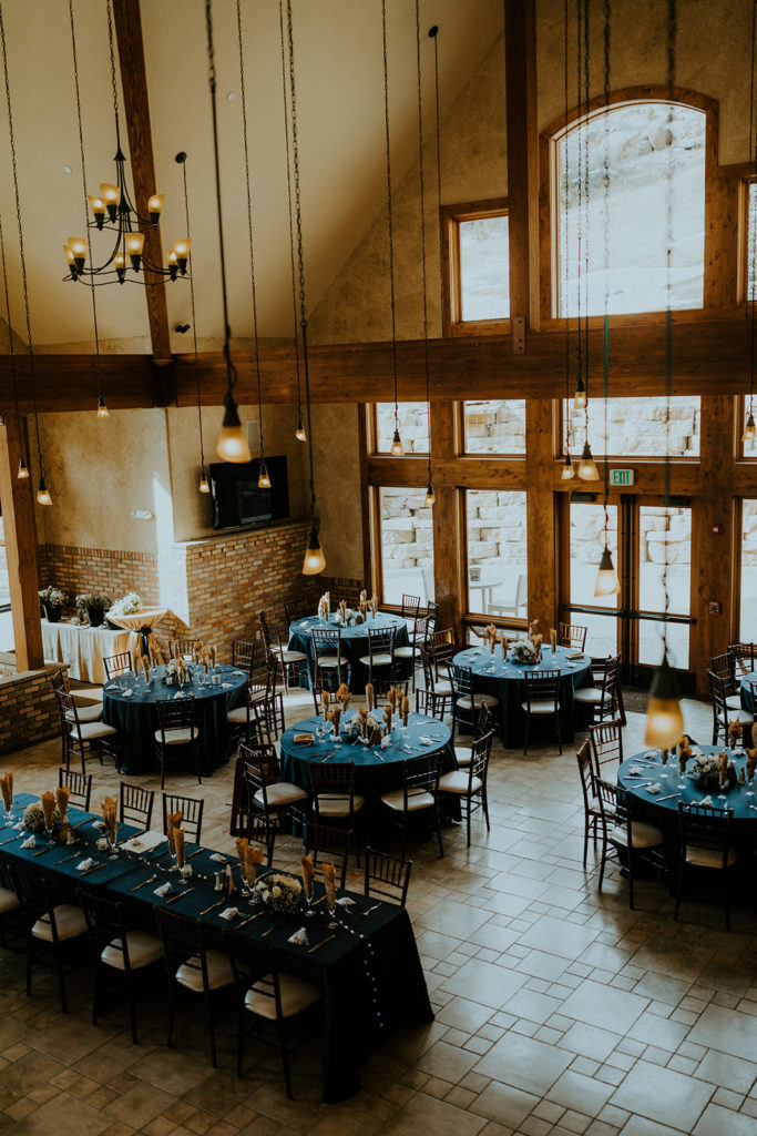 Della Terra Mountain Chateau Wedding Planning Guide + Pricing. Wedding reception hall with tall windows and tables set up.