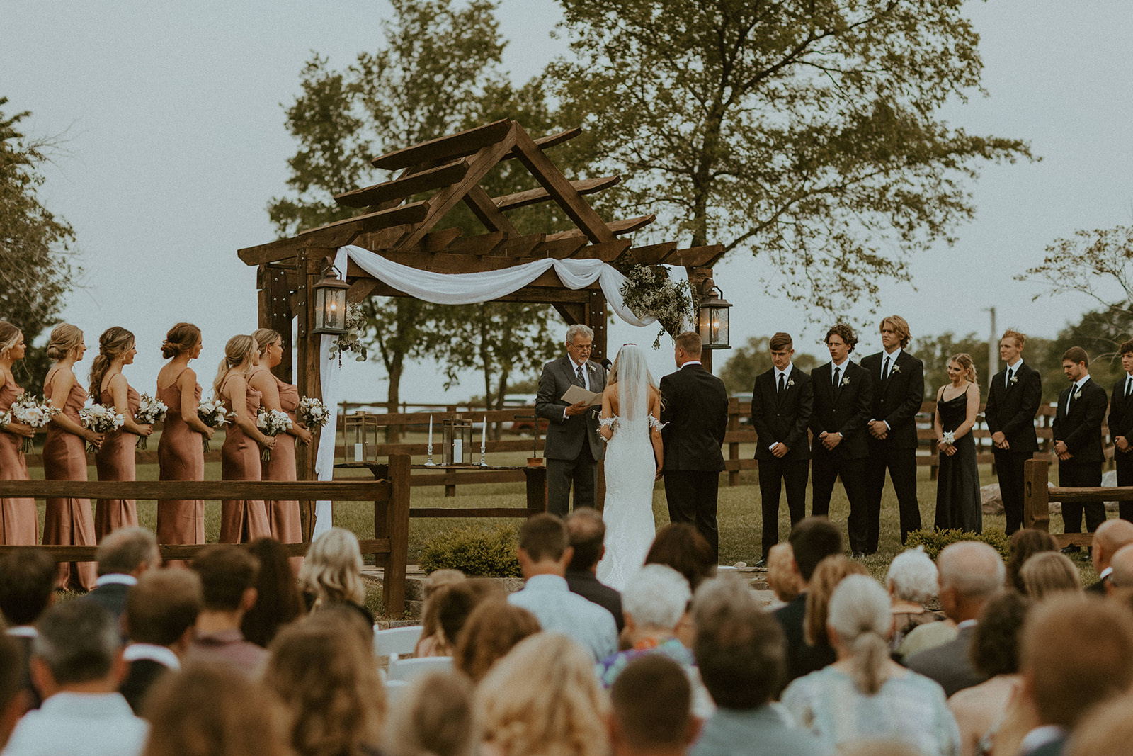 Bride and groom standing in front of officiant during the wedding ceremony at Roca Berry Farm