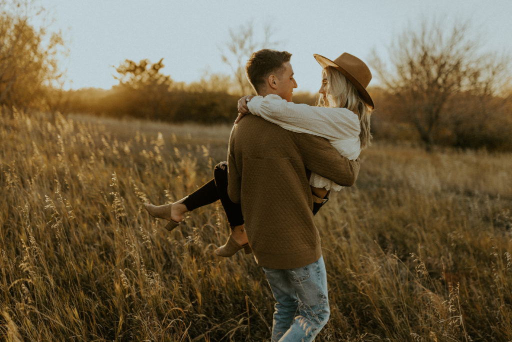 Guy carrying his fiance in his arms during their engagement shoot with McKenna Christine Photography