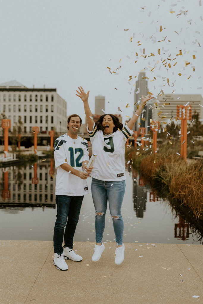 Couple wearing matching jerseys as they pop open confetti, captured by McKenna Christine Photography