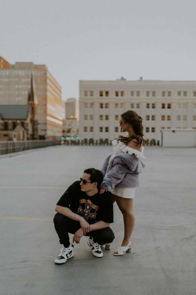 What to Wear For Engagement Photos + What NOT to Wear. Couple posing together as they wear sunglasses and look off to the side.