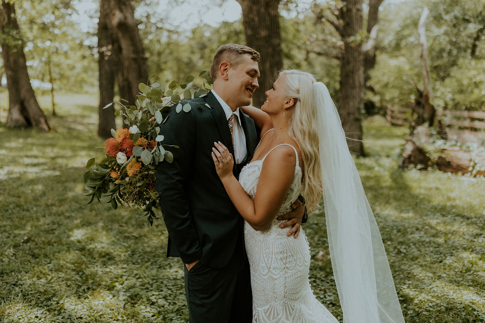 Bride and groom wrapping their arms around each other, shot by warm wedding photographer McKenna Christine