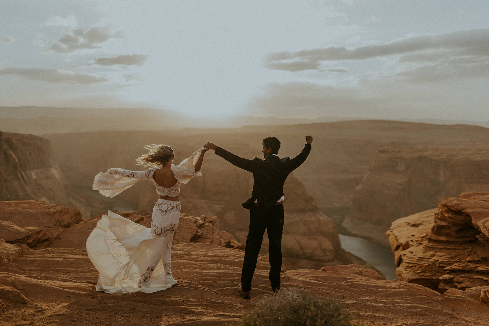 Bride and groom raising their intertwined hands during their elopement shoot in Arizona