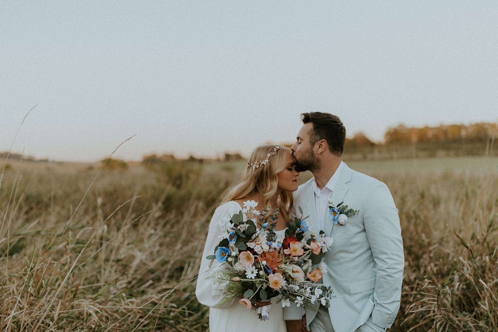 Groom planting a kiss on bride's forehead, captured by Omaha wedding photographer McKenna Christine